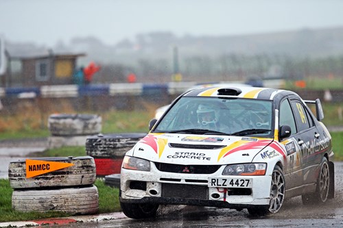 White and black rally car takes a fast corner at rally championship