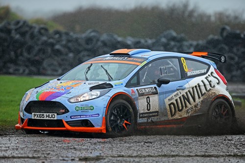 Blue and white rally car skidding in mud at McGrady Rally Championship event
